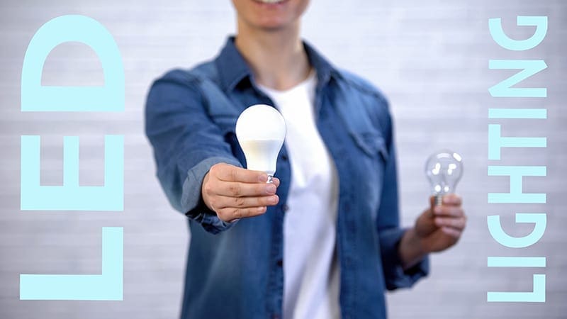 Girl chooses energy saving led bulb instead of incandescent lamp, efficiency